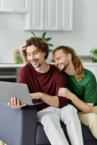 Un couple heureux partage un moment tendre tout en travaillant sur un ordinateur portable. — Photo de stock