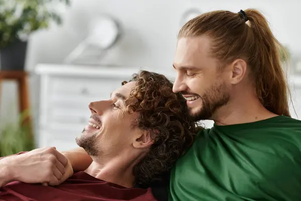 Affectionate partners share joyful laughter in their warm living room. — Stock Photo