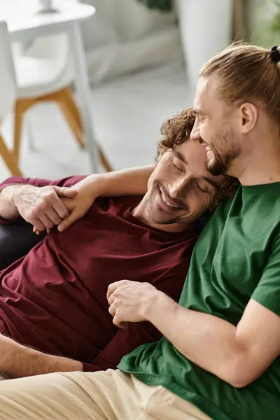 Two men share a joyful embrace, feeling love and happiness at home. — Stock Photo