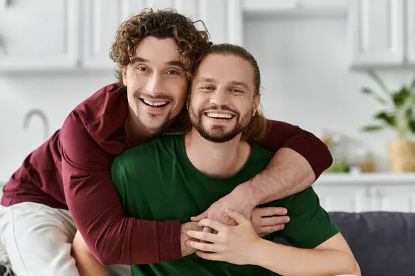 A joyful gay couple shares a loving embrace in their cozy home. — Stock Photo