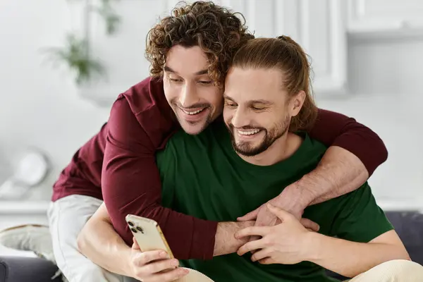 A joyful couple shares a lighthearted moment while looking at their phone. — Stock Photo