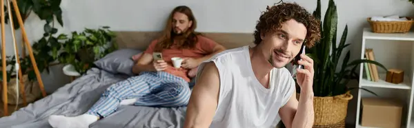 Two partners share a warm moment at home, one on a call and the other relaxing nearby. — Stock Photo