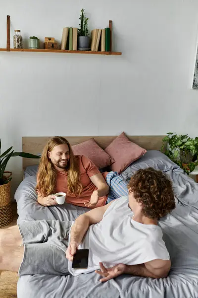 Cuddled in bed, a loving couple shares laughs and coffee in their cozy home. — Stock Photo