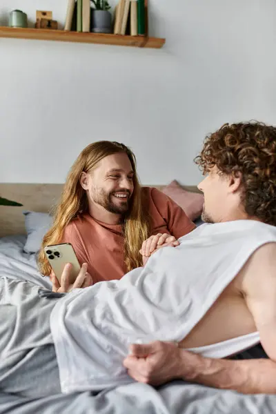 Two loving partners share laughter and joy while lounging in their inviting bedroom. — Stock Photo
