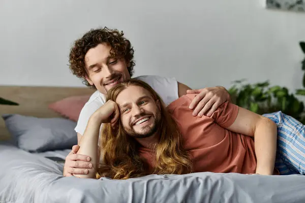 A joyful couple shares a heartfelt embrace on their serene bed. — Stock Photo