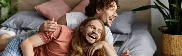 Два партнери діляться сміхом і любов'ю в затишній обстановці спальні. — стокове фото