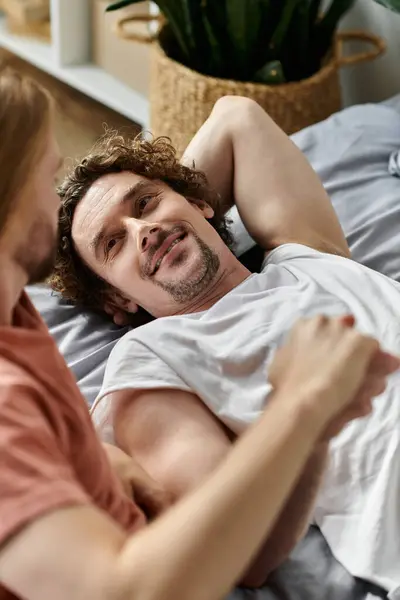 A loving couple relaxes together, sharing smiles and affection in their intimate space. — Stock Photo