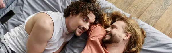 Loving couple shares affectionate smiles while relaxing in their cozy bedroom. — Stock Photo