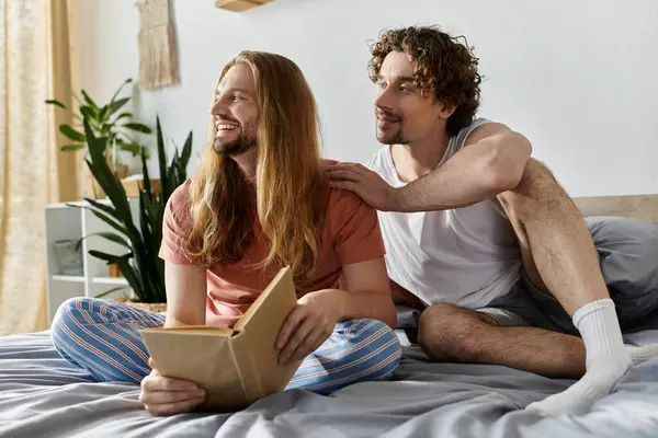 A couple shares a tender moment, reading and enjoying each other in bed. — Stock Photo