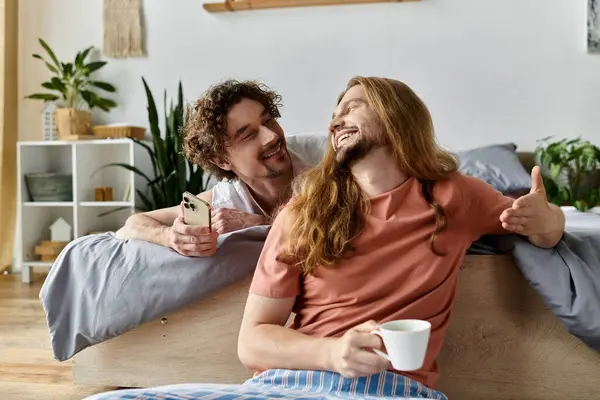 Two men share laughter and love while enjoying a cozy morning in their home. — Stock Photo