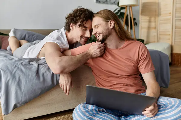 A couple shares a tender moment while relaxing and laughing at home. — Stock Photo