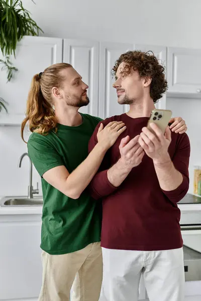 Two affectionate partners enjoy a tender moment while using a smartphone. — Stock Photo