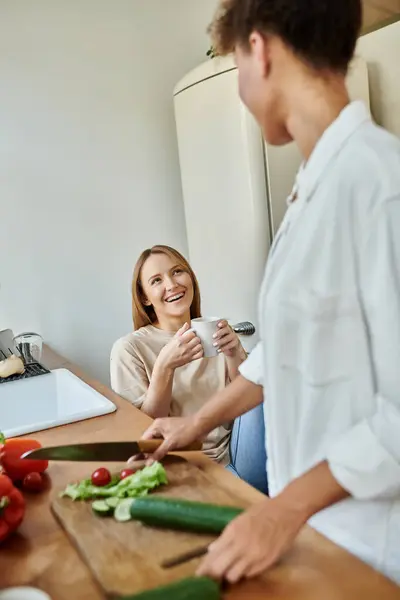 A cheerful couple shares laughter while preparing a meal in their kitchen. — Stock Photo