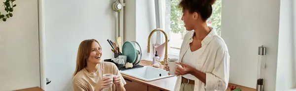 Two partners share a joyful moment over coffee in a sunny kitchen. — Stock Photo