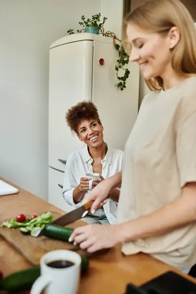 Amantes socios comparten sonrisas mientras preparan una comida en su acogedora cocina. - foto de stock