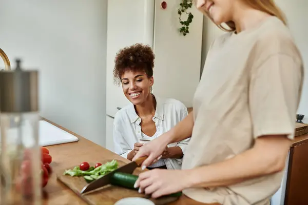 Deux partenaires partagent la joie tout en préparant un repas dans leur cuisine accueillante. — Photo de stock