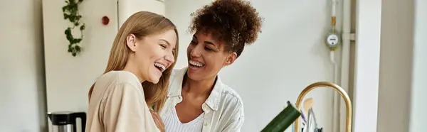 Two happy partners enjoy cooking and sharing laughter in their warm kitchen. — Stock Photo