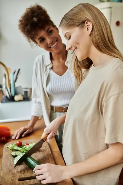 A loving couple prepares a fresh meal, sharing smiles and laughter in their cozy kitchen. — Stock Photo