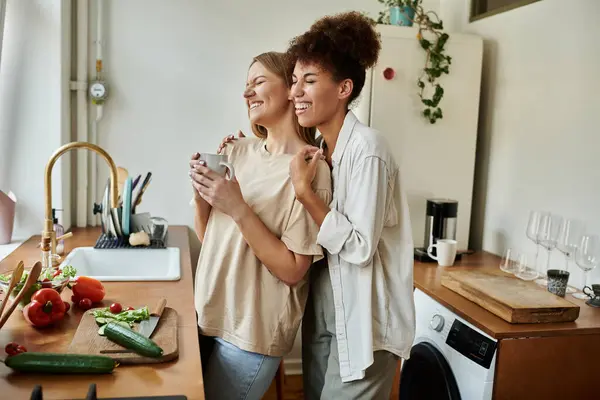 Two partners share a delightful moment while preparing meals in their warm kitchen. — Stock Photo