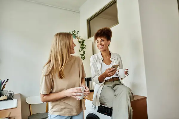 Two partners share a warm moment while sipping coffee in their inviting living space. — Stock Photo