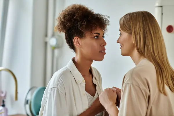 Loving partners share a tender gaze while holding hands together indoors. — Stock Photo