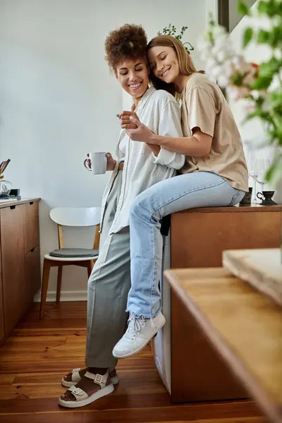 Two partners share laughter and warmth in a sunlit kitchen. — Stock Photo