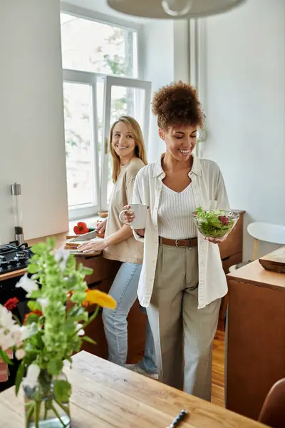 Two partners share laughter while cooking in a cozy, bright kitchen. — Stock Photo
