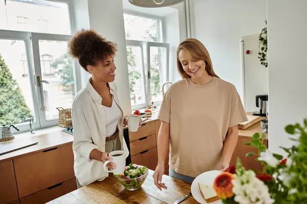 Due partner condividono un momento di gioia durante il pranzo nella loro cucina calda. — Foto stock