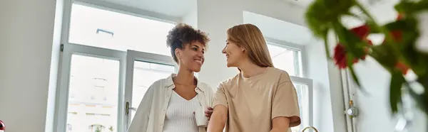 Two women share joyful moments in a cozy, bright space filled with plants. — Stock Photo