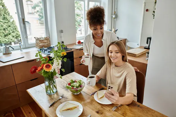 Um casal feliz compartilhando momentos durante o café da manhã em uma cozinha brilhante. — Fotografia de Stock