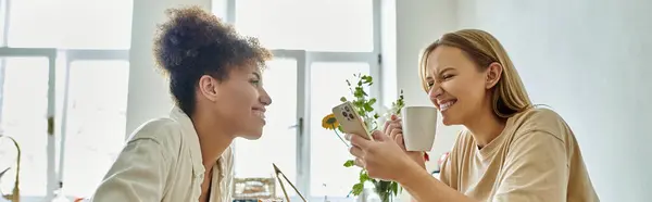 Dois parceiros compartilham risos e amor enquanto navegam em seus telefones. — Fotografia de Stock