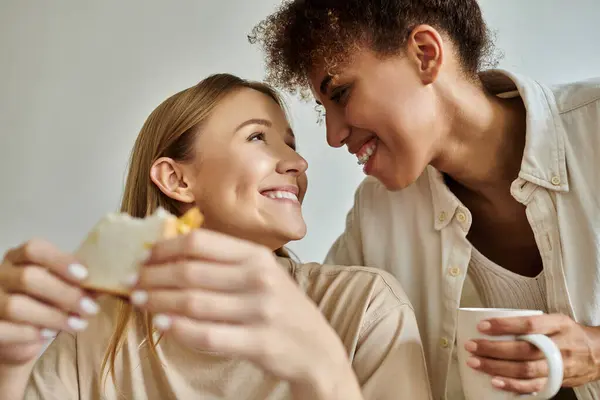 A joyful couple shares laughter and food while enjoying their time together. — Stock Photo