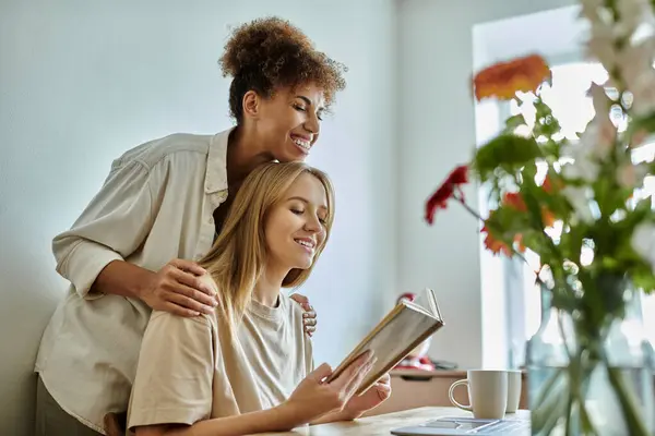 Two partners enjoy a moment of connection while reading in a bright space. — Stock Photo