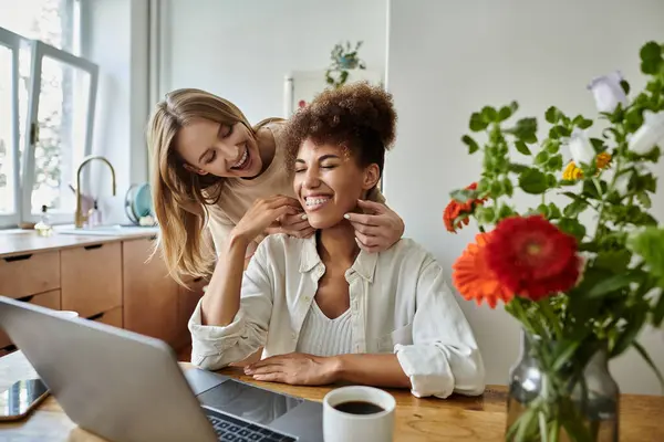 Una pareja cariñosa comparte la risa mientras trabajan juntos en casa en una cocina luminosa. — Stock Photo