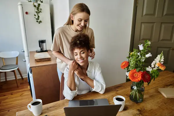 Loving couple shares a joyful moment while working at their cozy kitchen table. — Stock Photo