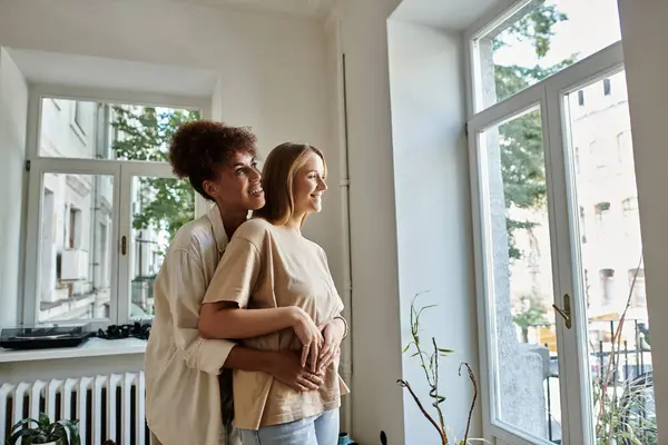 Liebendes Paar umarmt sich herzlich und genießt einen ruhigen Moment am sonnigen Fenster. — Stockfoto