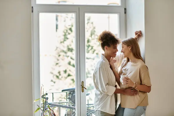 Una pareja feliz comparte la risa y el afecto en un espacio cálido y acogedor. - foto de stock