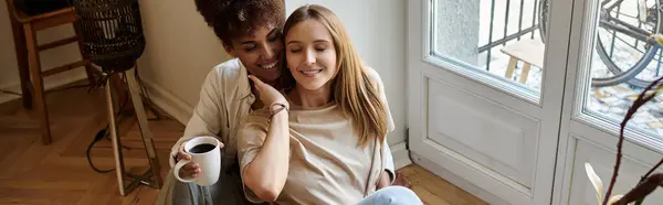 A joyful LGBT couple shares an intimate moment over coffee in their cozy home. — Stock Photo