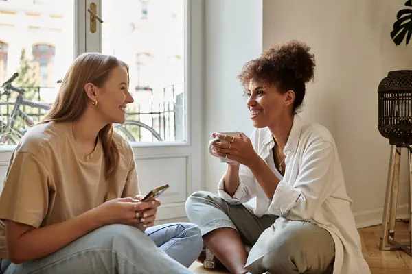 Two partners share laughter and warmth over coffee in their inviting home. — Stock Photo