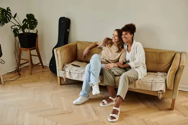 Two partners share laughter and affection on a comfortable sofa. — Stock Photo