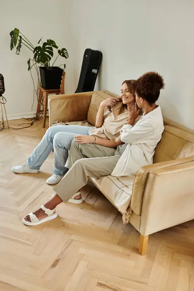 Two happy partners share laughter and affection on their comfy sofa. — Stock Photo