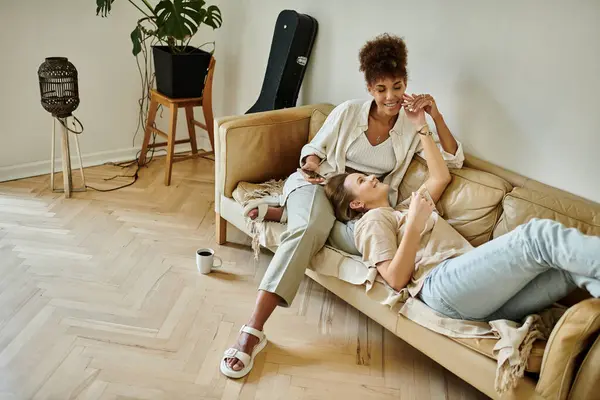 A loving couple shares laughter and affection on their comfortable couch. — Stock Photo