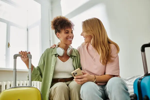 Two women share smiles and laughter as they plan their travels. — Stock Photo