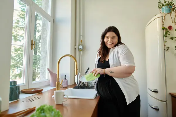 Eine fröhliche Frau wäscht Gemüse an ihrer charmanten Küchenspüle. — Stockfoto