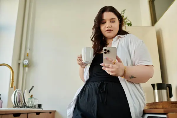 A stylish woman savoring her coffee while checking her phone. — Stock Photo