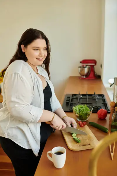 Una donna taglia con gioia le verdure mentre si gode il suo tempo a casa. — Foto stock