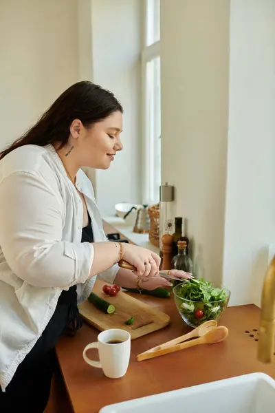 A plus size woman skillfully prepares a healthy salad at her cozy home. — Stock Photo