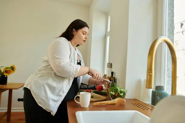 Una donna sicura di sé crea un'insalata vibrante nella sua accogliente cucina. — Foto stock