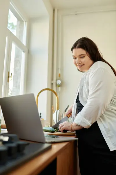 A cheerful woman prepares healthy food while enjoying her cozy kitchen. — Stock Photo