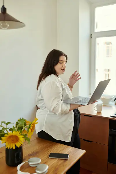 A confident woman engages in work while enjoying a bright, cozy home environment. — Stock Photo